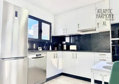a kitchen with white cabinets and a refrigerator at Atlantic Harmony Residences in Funchal
