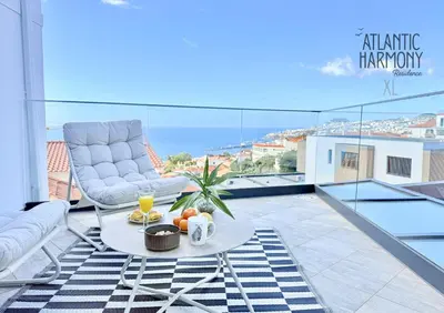 a living room with a table and chairs on a balcony at Atlantic Harmony Residences in Funchal