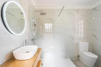 a white bathroom with a sink and a mirror at Casa do Vale in São Vicente