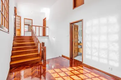 a staircase in a home with white walls and wooden floors at Casa do Vale in São Vicente