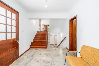a hallway with a wooden door and stairs at Casa do Vale in São Vicente