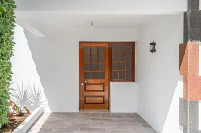 a wooden door on the side of a white house at Casa do Vale in São Vicente