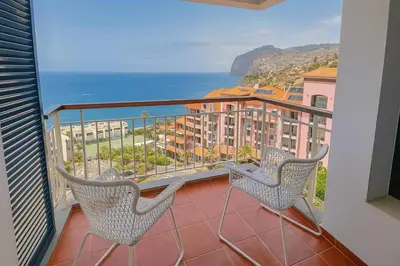a balcony with two chairs and a view of the ocean at Frutti studio by Turin in Funchal