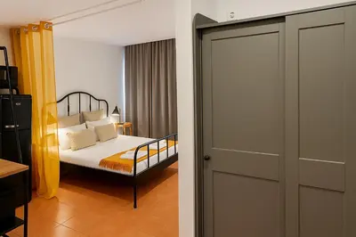 a bedroom with a bed and a sliding door at Frutti studio by Turin in Funchal