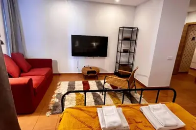 a living room with a red couch and a flat screen tv at Frutti studio by Turin in Funchal