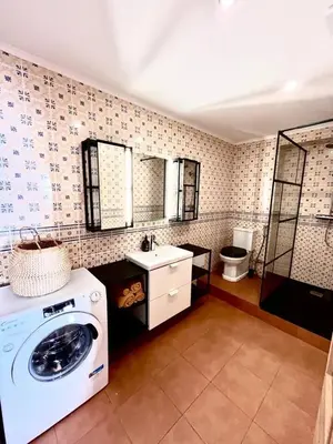 a bathroom with a washing machine and a sink at Frutti studio by Turin in Funchal