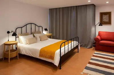 a bedroom with a bed and a red chair at Frutti studio by Turin in Funchal