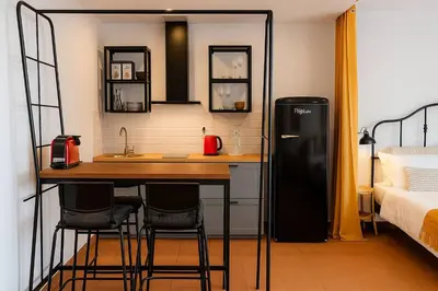 a kitchen with a refrigerator and a table in a room at Frutti studio by Turin in Funchal