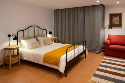 a bedroom with a bed and a red chair at Tutti studio by Turin in Funchal