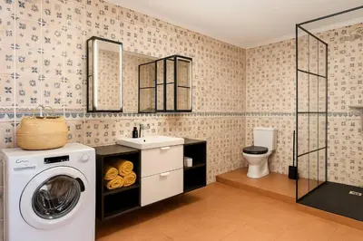 a bathroom with a washing machine and a sink at Tutti studio by Turin in Funchal