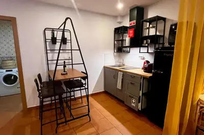 a kitchen with a black refrigerator and a table at Tutti studio by Turin in Funchal