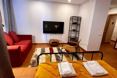 a living room with a red couch and a flat screen tv at Tutti studio by Turin in Funchal