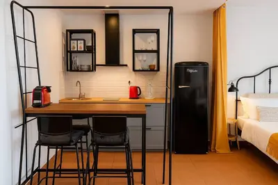 a kitchen with a refrigerator and a table in a room at Tutti studio by Turin in Funchal