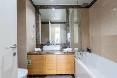 a bathroom with a tub and a sink and a mirror at Bogi's APT by LovelyStay in Funchal
