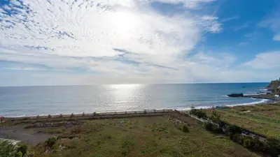 a view of the ocean with the sun in the sky at Bogi's APT by LovelyStay in Funchal