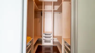 an empty walk in closet with wooden cabinets at Bogi's APT by LovelyStay in Funchal
