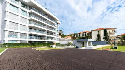 a large white apartment building with a parking lot at Bogi's APT by LovelyStay in Funchal