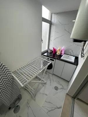a white kitchen with a laptop sitting on a chair at Heart of Madeira Funchal in Funchal
