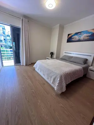 a bedroom with a large bed and a large window at Heart of Madeira Funchal in Funchal