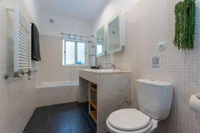 a bathroom with a toilet and a sink and a tub at Duas Palmeiras in Aljezur