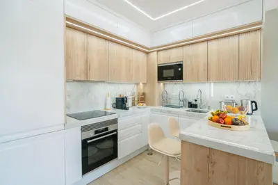 a kitchen with white cabinets and a bowl of fruit on a counter at Linda Vista Apartment by Amazing Madeira in Funchal