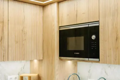 a black microwave in a kitchen with wooden cabinets at Linda Vista Apartment by Amazing Madeira in Funchal