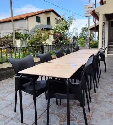 a restaurant with wooden benches and a table and a balcony at IlhaMontanha - Serras da Ilha in Santana