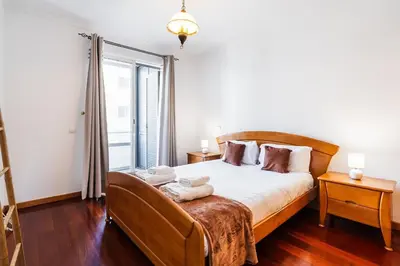 a hanging chair with a pillow on a balcony at GuestReady - Charming Apartment with Ocean Views in Caniço