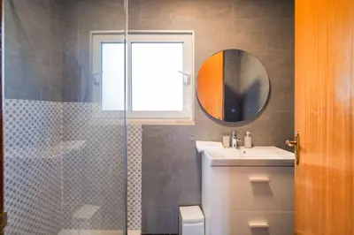 a bathroom with a sink and a shower with a mirror at GuestReady - Machico Apartment with Balcony in Machico