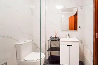 a white bathroom with a toilet and a sink at GuestReady - Machico Apartment with Balcony in Machico