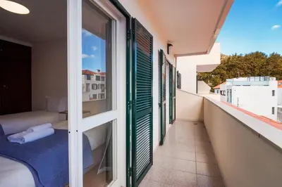 a balcony with a bed and a window at GuestReady - Machico Apartment with Balcony in Machico