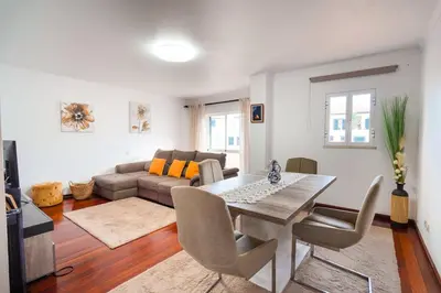 a living room with a table and a couch at GuestReady - Machico Apartment with Balcony in Machico