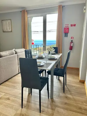 a dining room with a table and chairs and a couch at Estrela House III, Calheta, Madeira in Calheta