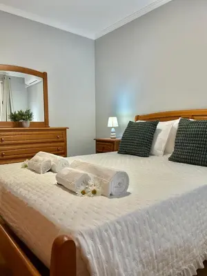 a bedroom with a bed with towels and a mirror at Estrela House III, Calheta, Madeira in Calheta