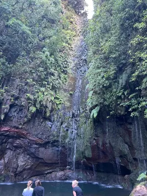 three people standing in the water near a waterfall at Estrela House III, Calheta, Madeira in Calheta