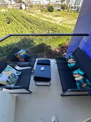 a balcony with two chairs and a table with pillows at Heart of Madeira SEASIDE in Funchal