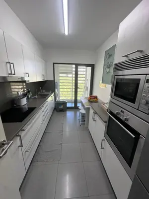 a large kitchen with white cabinets and appliances at Heart of Madeira SEASIDE in Funchal