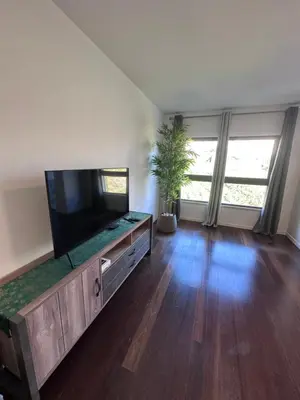 a living room with a flat screen tv on a entertainment center at Heart of Madeira SEASIDE in Funchal
