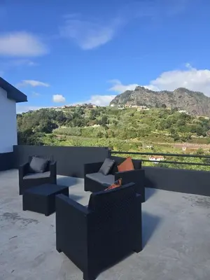 a patio with couches and a view of a mountain at Casa Rosa in Porto da Cruz