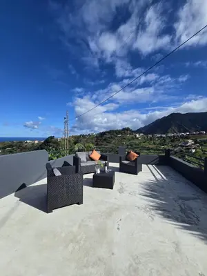 a patio with couches sitting on top of a roof at Casa Rosa in Porto da Cruz