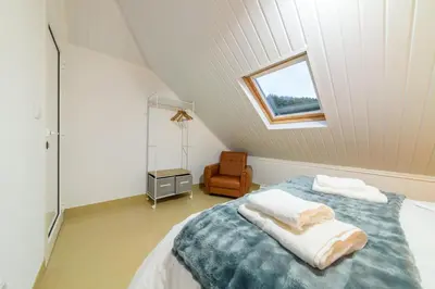 a attic bedroom with a bed and a window at Banda Além Apartment by Mth in Tábua