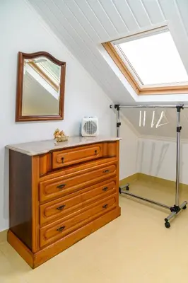 a bedroom with a dresser with a mirror and a skylight at Banda Além Apartment by Mth in Tábua
