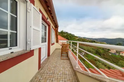 a balcony of a house with two chairs on it at Banda Além Apartment by Mth in Tábua