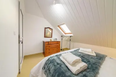 a attic bedroom with a bed and a dresser at Banda Além Apartment by Mth in Tábua