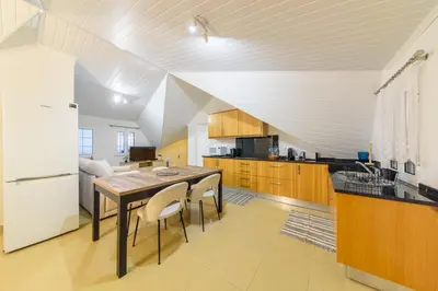 a kitchen with a table and a white refrigerator at Banda Além Apartment by Mth in Tábua