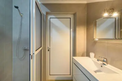 a bathroom with a shower and a sink and a mirror at Banda Além Apartment by Mth in Tábua