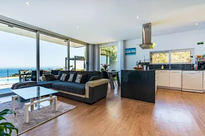 a living room with a couch and a table at Villa Pinheira III heated pool in Calheta