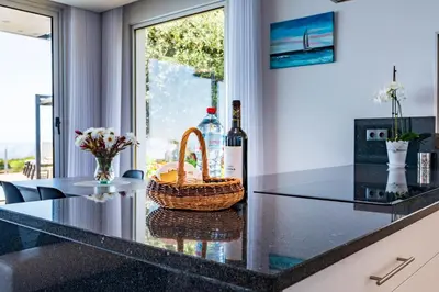 a counter with two bottles of wine and a basket at Villa Pinheira III heated pool in Calheta