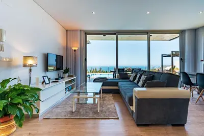 a living room with a couch and a table at Villa Pinheira III heated pool in Calheta