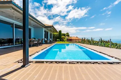 a swimming pool in the backyard of a house at Villa Pinheira III heated pool in Calheta